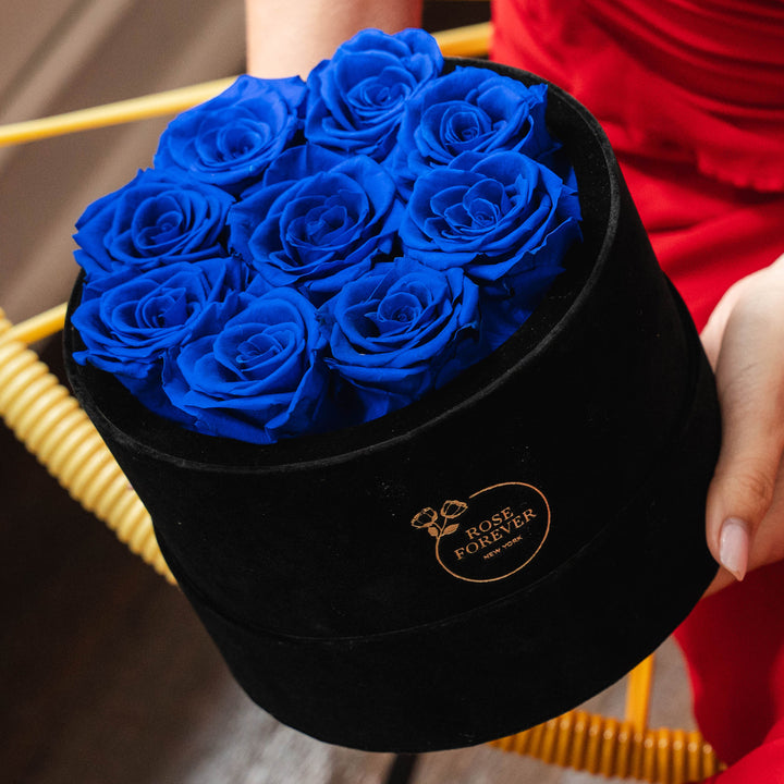 9 royal blue roses in a black velvet box